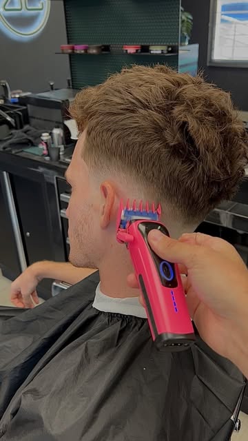 Dégradé en cours à la tondeuse rose sur la nuque d’un client
