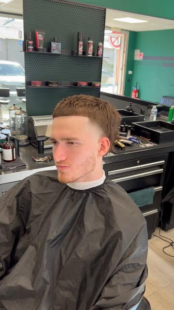 Client dans le fauteuil, coupe en dégradé fraîchement terminée